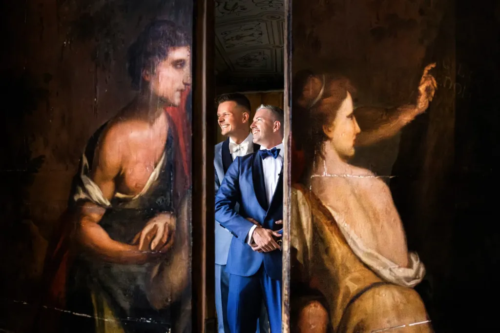 Two grooms between painted wooden doors in a historic villa, Italy