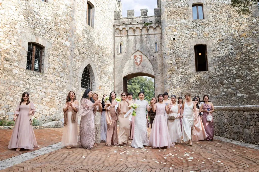 Bride and bridesmaids in a castle courtyard, Italy