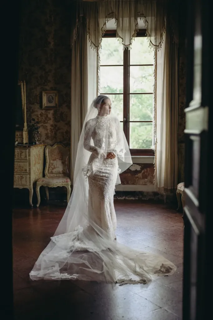 Bride getting ready by the window of a historic villa, Siena